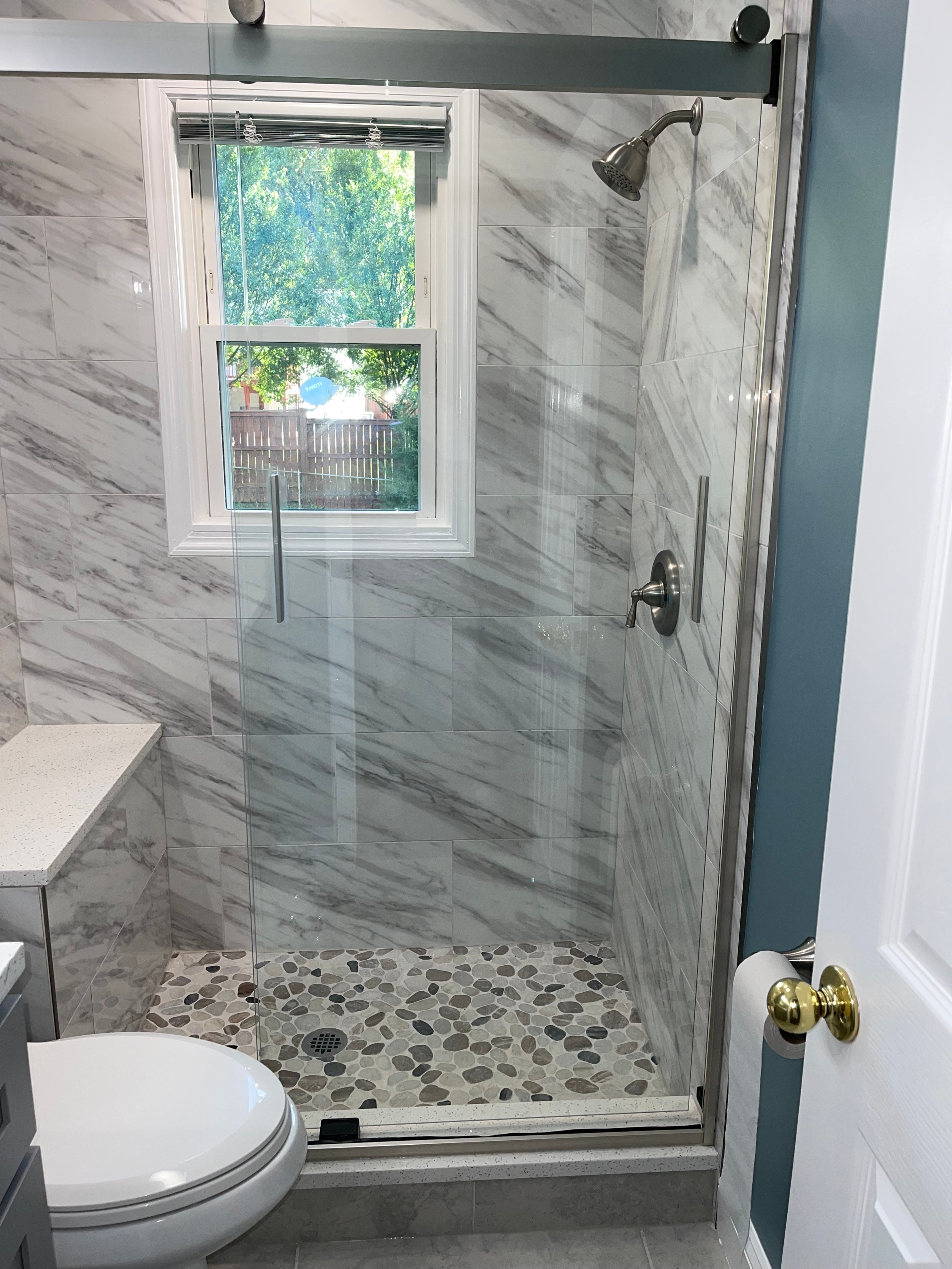 A bathroom sink with a marble countertop and white cabinets