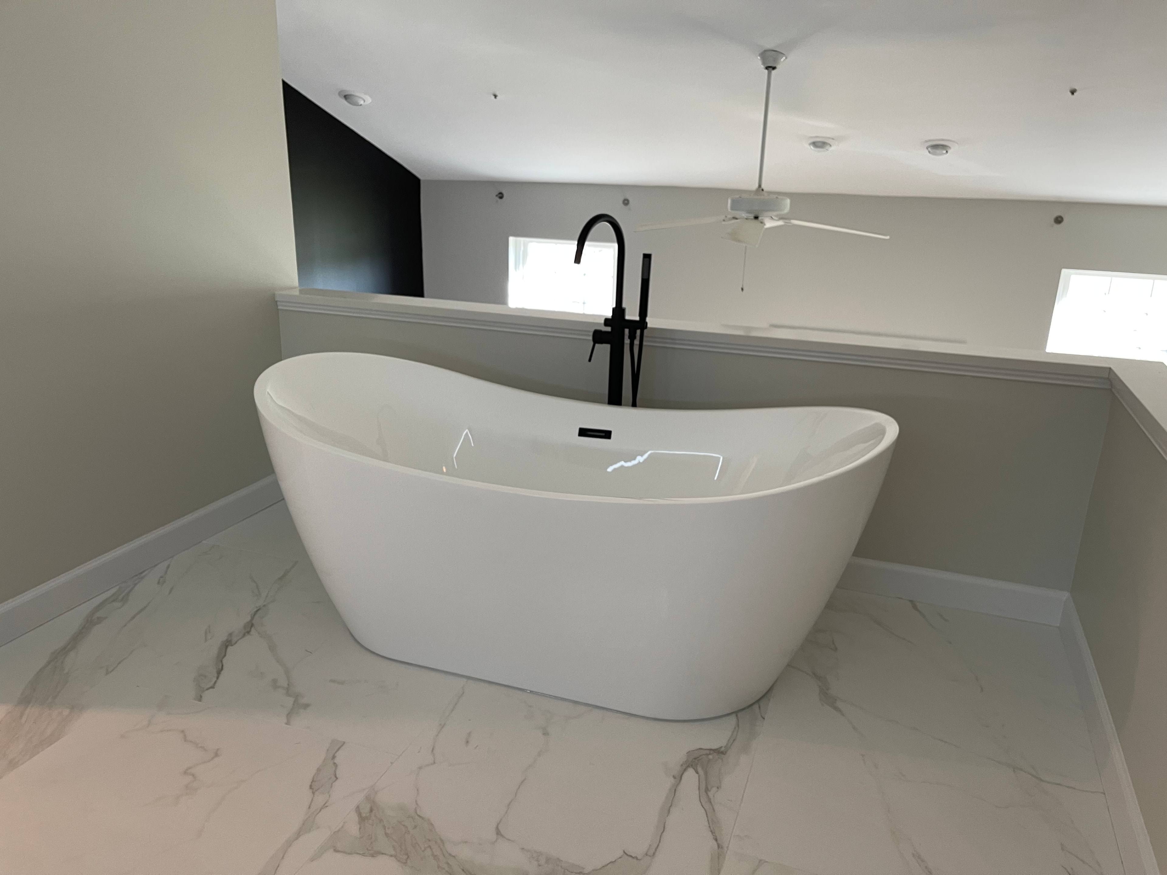 A bathroom with a bathtub, sinks, and a window