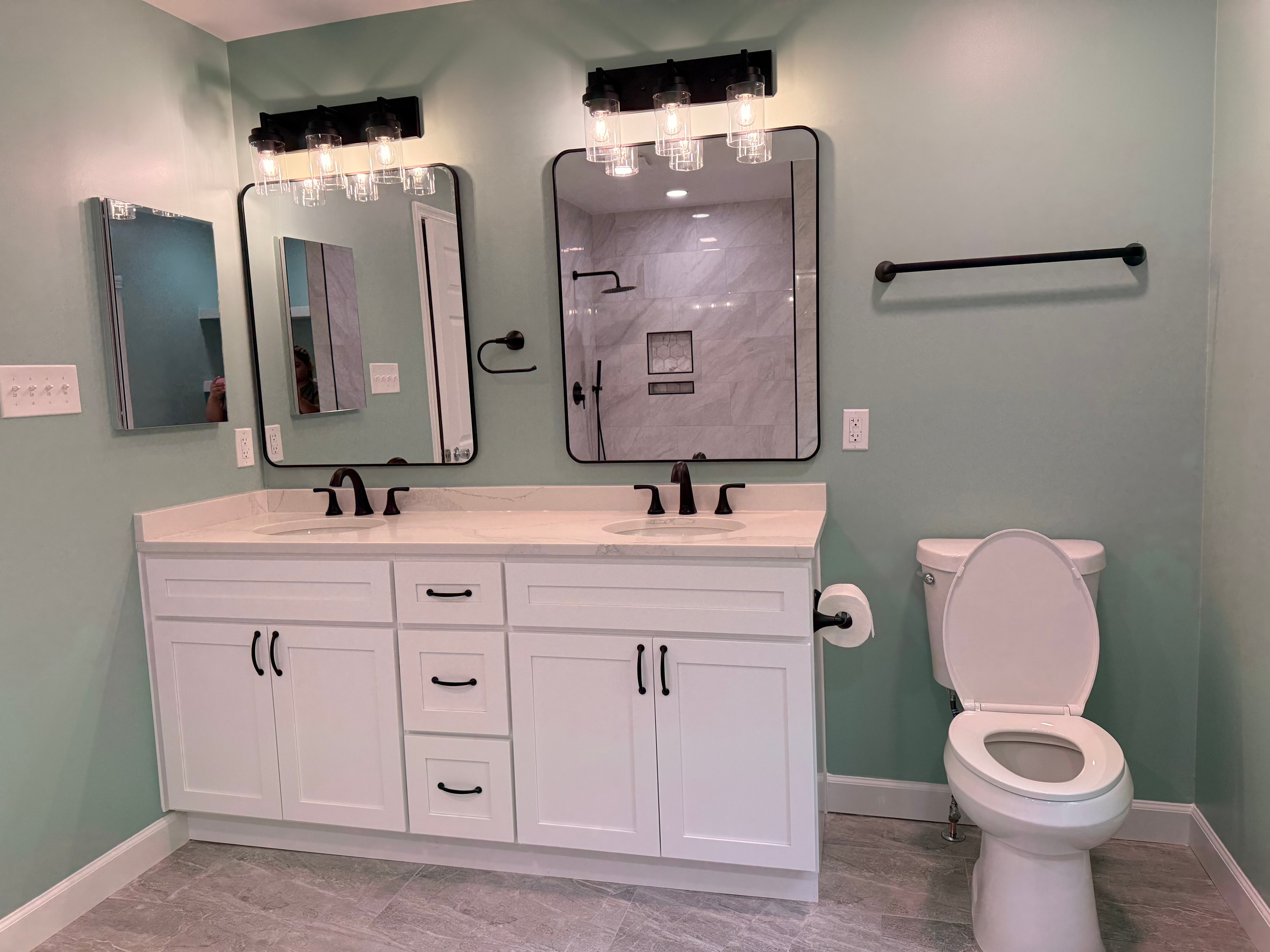 A bathroom with a toilet, a sink and a mirror